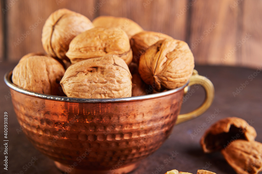 Walnuts in a tin cup, whole and finely chopped, next to the filling and shell. Home storage of winter preparations Walnuts in a tin cup, whole and finely chopped, next to the filling and shell. Home storage of winter preparations