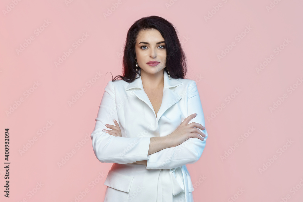 charming brunette with long hair and a white suit. photo shoot on a pink background charming brunette with long hair and a white suit. photo shoot on a pink background