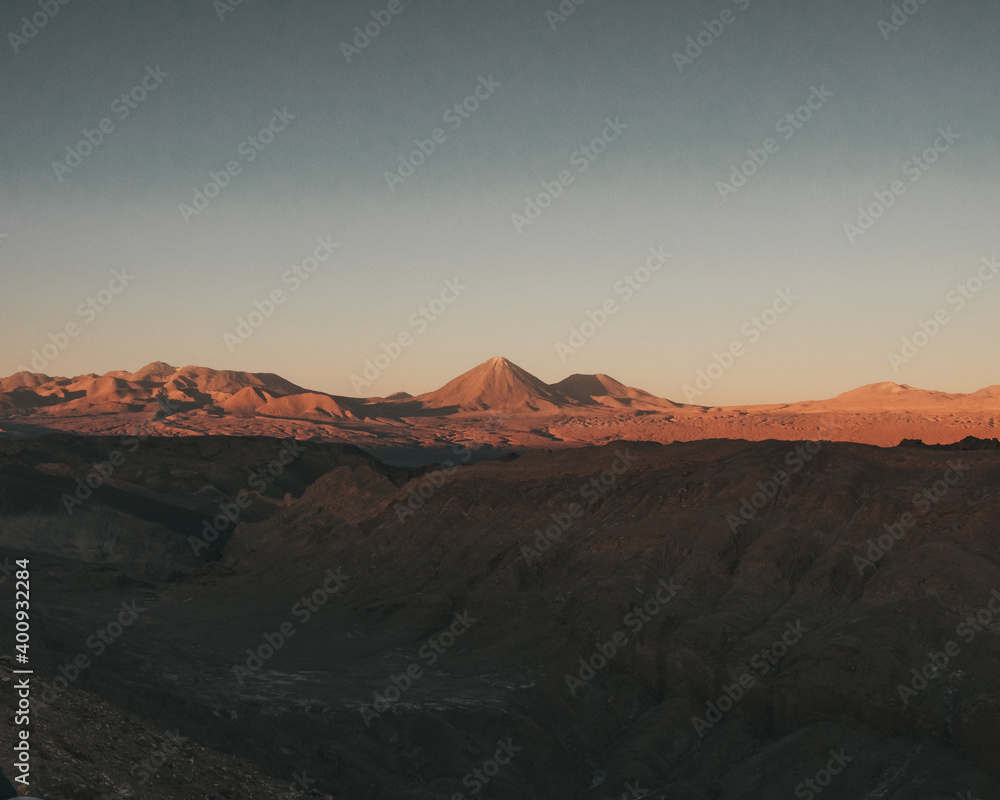 Naklejka premium View of the mountains and a vulcano in the desert during sunset