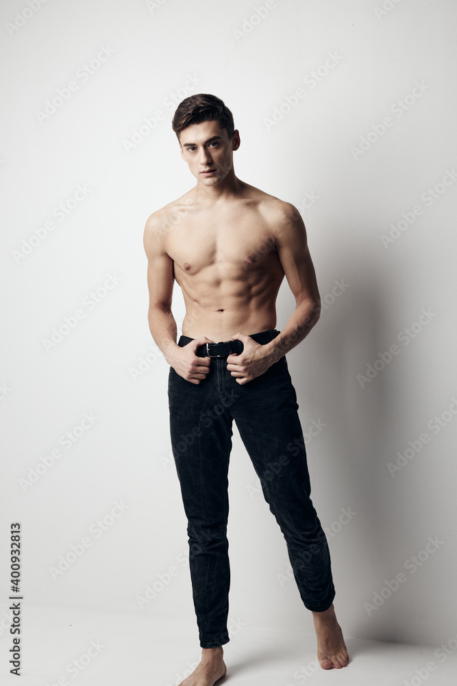 A gentleman in full-length trousers on a light background and a naked torso A gentleman in full-length trousers on a light background and a naked torso