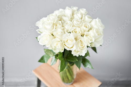 White rose in a vase . Summer background. Bouquet of roses present for Mothers Day. Photo of Flowers for a catalog of flower online store and delivery.
