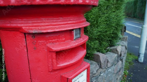 Letters are posted into a red royal mail letter post box in England.