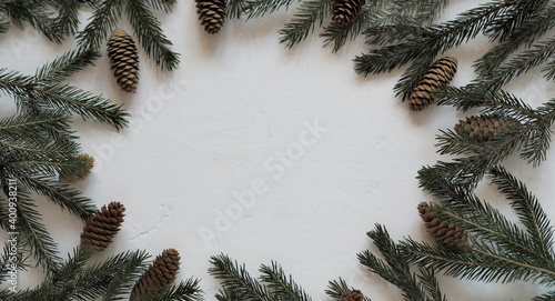 Place for congratulations or text surrounded by fir branches on a white background. Selective focus.