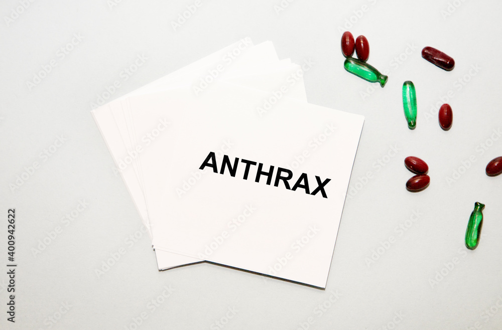 On the sheets for notes the text of ANTHRAX, next to green and red capsules.