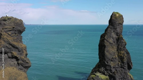 High definition drone aerial video flying over volcanic rock formations along  Atlantic Ocean Coastline near Vik, Iceland.