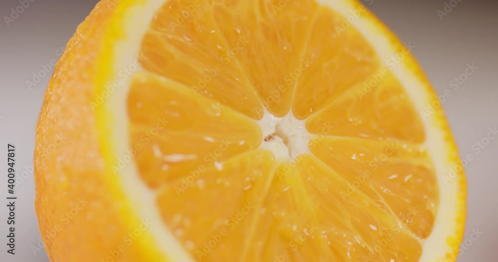 Half of juicy orange with water drops flowing down. Macro shot Half of juicy orange with water drops flowing down. Macro shot