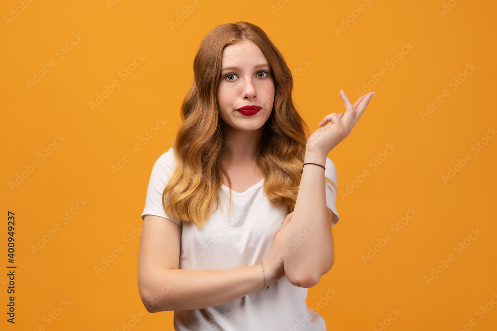 Studio shot of displeased girl with wavy redhead, gesturing with raised palm, frowning. Human emotions concept Studio shot of displeased girl with wavy redhead, gesturing with raised palm, frowning. Human emotions concept