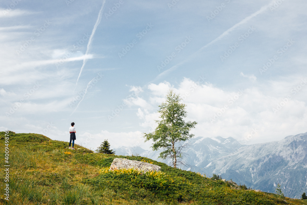 Obraz premium une personne regardant le paysage de montagne. Un garçon regarde les montagnes et pense à la vie.