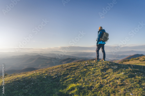 Top of the mount at sunset light.Concetto di successo. Donna in piedi in cime ad una montagna.