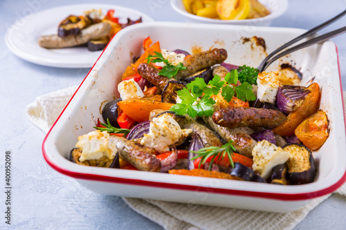 Roasted sausages with vegetables and feta cheese