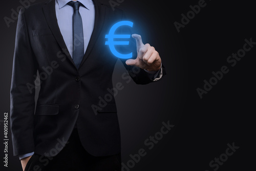 Businessman holds money coin icons EUR or Euro on dark tone background..Growing money concept for business investment and finance