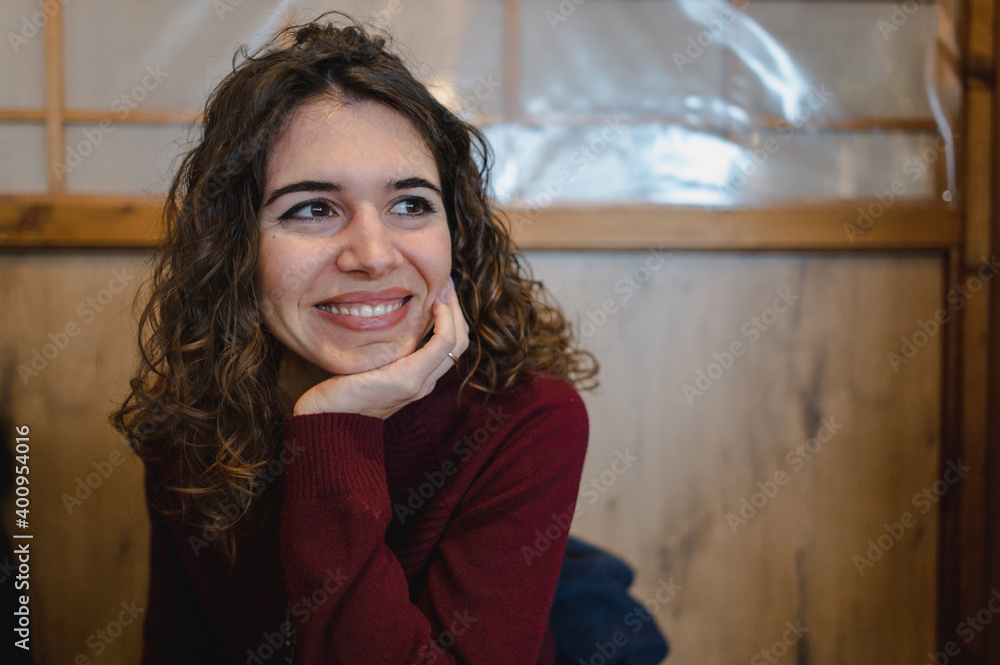 Close-up caucasian young woman portrait smiling looking at her side with chin on hand. Close-up caucasian young woman portrait smiling looking at her side with chin on hand.