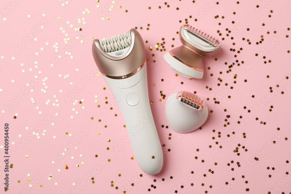Fototapeta premium Epilator and glitter on pink background, top view