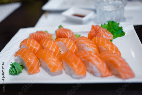 Close-up salmon nigiri sushi on decorated plate in table restaurant. Japanese healthy food concept.