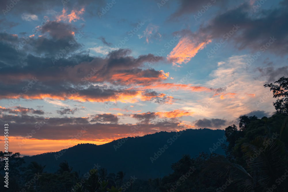 Panorama of a forest valley with mountains at colorful sunset. View from the balcony.