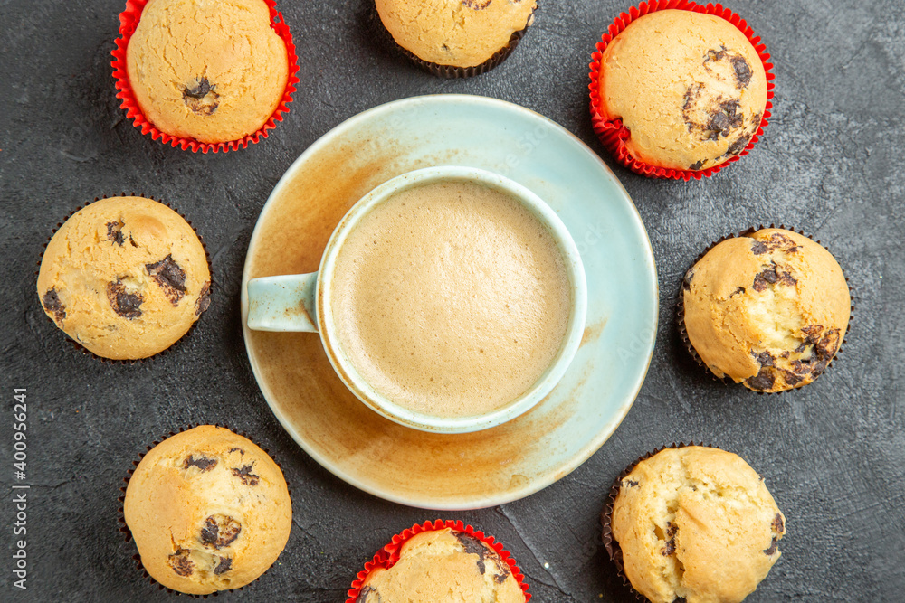 Overhead view of delicious coffee around small cupcakes on dark background Overhead view of delicious coffee around small cupcakes on dark background