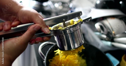 Pressing mandioca food, close-up hands preparing mandioc with presser