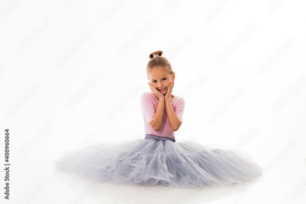 Naklejka premium Little ballerina posing on a white background