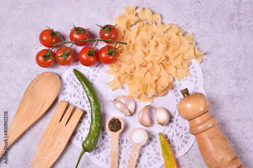 Red cherry tomato with peper mill and wooden spoon garlic origan and green paprika with pastry