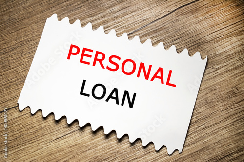 personal loan is written on a white sheet that lies on a wooden table. Concept photo