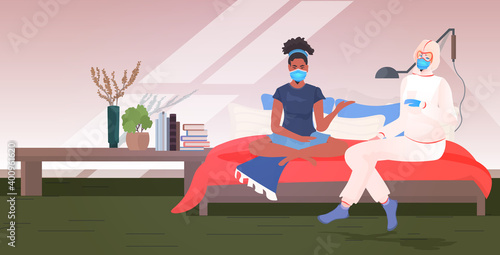 doctor in mask and protective suit examining african american woman patient on bed covid-19 pandemic concept home bedroom interior horizontal full length vector illustration