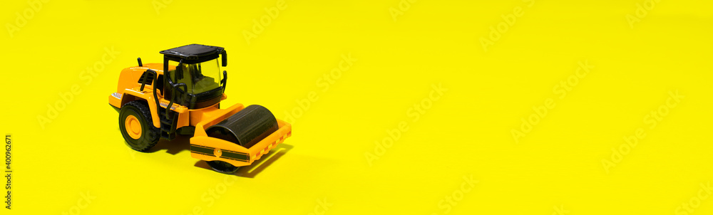 Children's toy typewriter skating rink roller machine on a yellow background. Banner for a toy store with a place for copy space text. Truck tractor for the boy