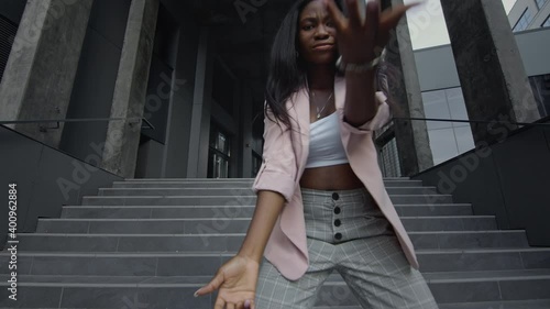 Young Black Girl Dancing Modern Dance On The Stairs. She Is In Business Clothes With High Heels.