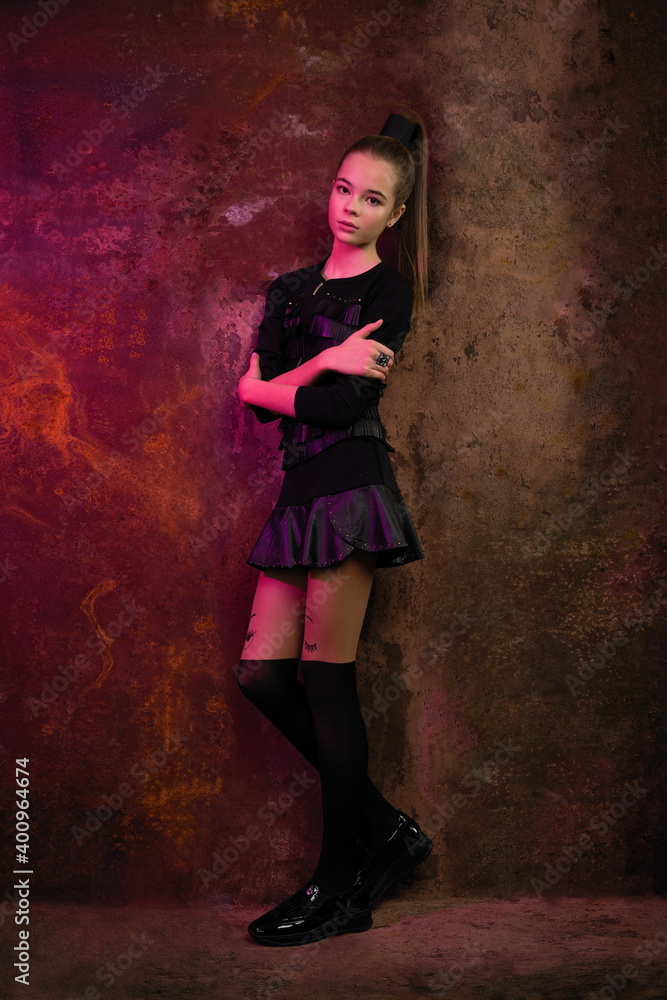 beautiful girl in a stylish dress posing against a background of rusty iron beautiful girl in a stylish dress posing against a background of rusty iron