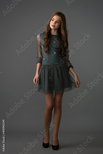 beautiful girl in a stylish dress posing in the studio