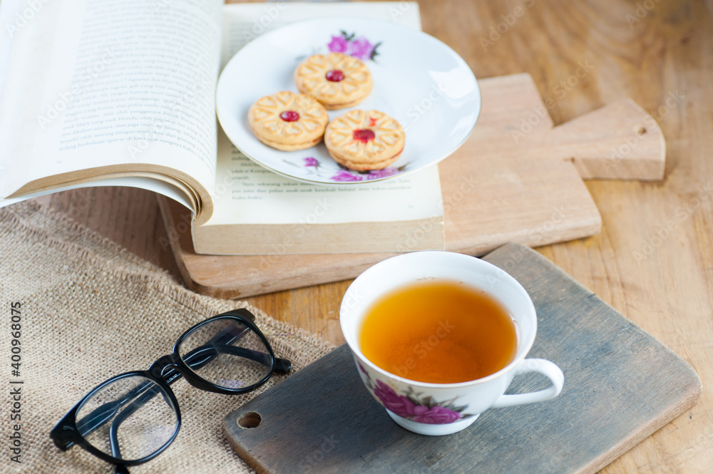 a cup of tea with a book and cake as decor a cup of tea with a book and cake as decor