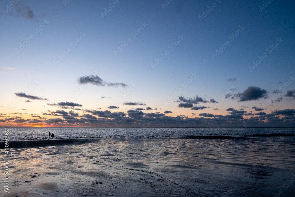 View of the setting sun shining on the Sea and reflected on the beach, clouds with sun-shining edges. Landscape. High quality photo showing concept of freedom and dreams