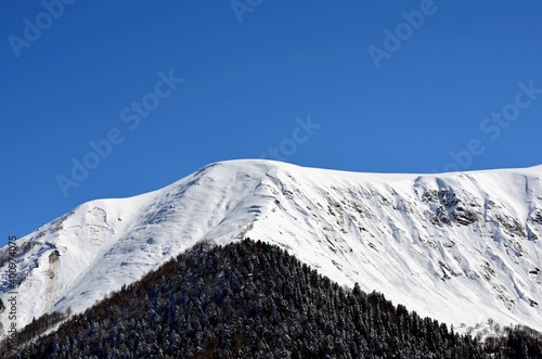 Mountain landscape, winter in the mountains, peaks and snowy peaks, ski slopes.