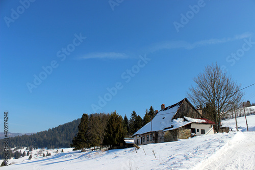Winter countryside with wooden cottage © Karol