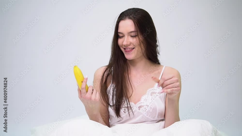 Cute young woman chooses between a banana and an apple Cute young woman chooses between a banana and an apple