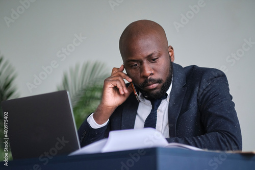 angry young African American businessman. Entrepreneur angry and furious with a laptop in a little office or home.