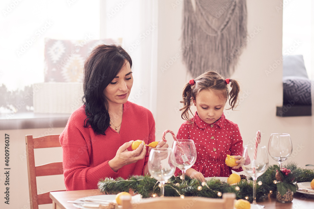 mom and daughter woman girl dinner christmas in the kitchen at the table playing morning new year's