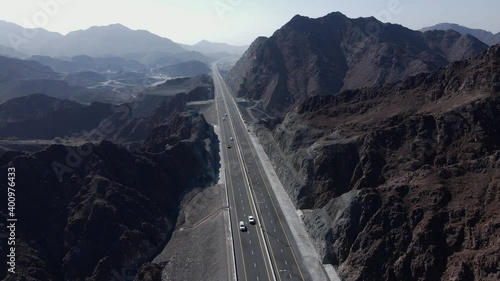 Rear drone view of UAE Mountain range, Traffic movement in between the Khorfakkan mountains, Sharjah, United Arab Emirates. 4k footage  photo