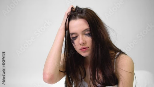 Young woman with spreading makeup on her face
