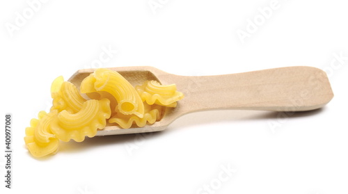 Pasta cornetti creste macaroni pile with wooden spoon isolated on white background