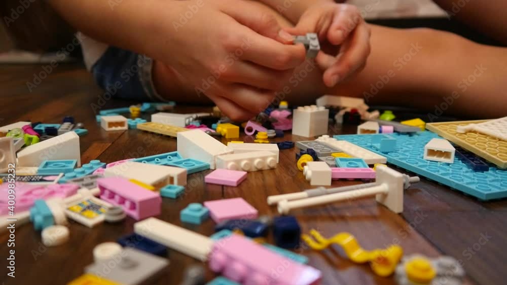 A Girl Kid plays blocks Plastic Blocks on a House Room Floor A Girl Kid plays blocks Plastic Blocks on a House Room Floor