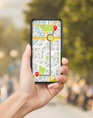 Woman Using Online Maps On Mobile Phone For Navigation In City