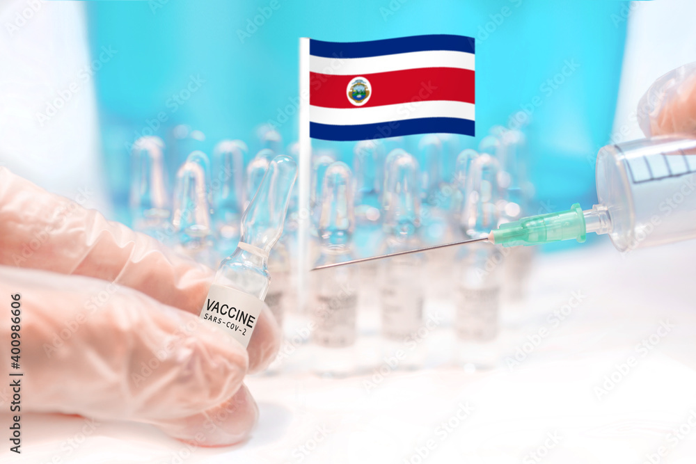 Hands holding a vaccine vial and a syringe with rows of the same