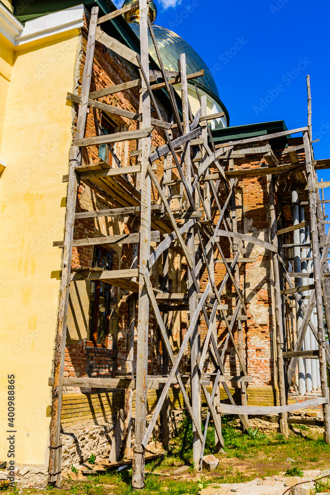 Wooden scaffolding near the old building. Ancient building restoration