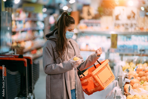 Young woman in protective mask makes purchases