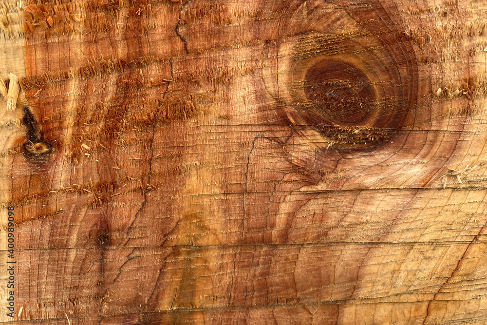 Naklejka premium Brown wooden background. A cut of natural wood. Top view. Natural raw non-planed texture timber of coniferous pine. The surface of the table to shoot flat lay in the grunge style. Copy space
