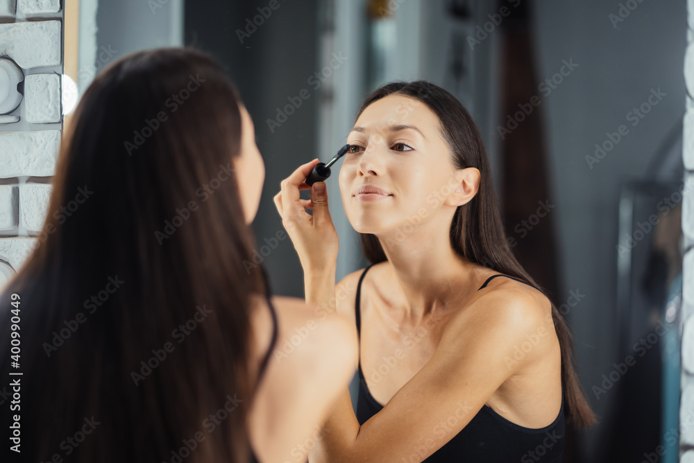 Reflection of young beautiful woman applying her make-up Reflection of young beautiful woman applying her make-up