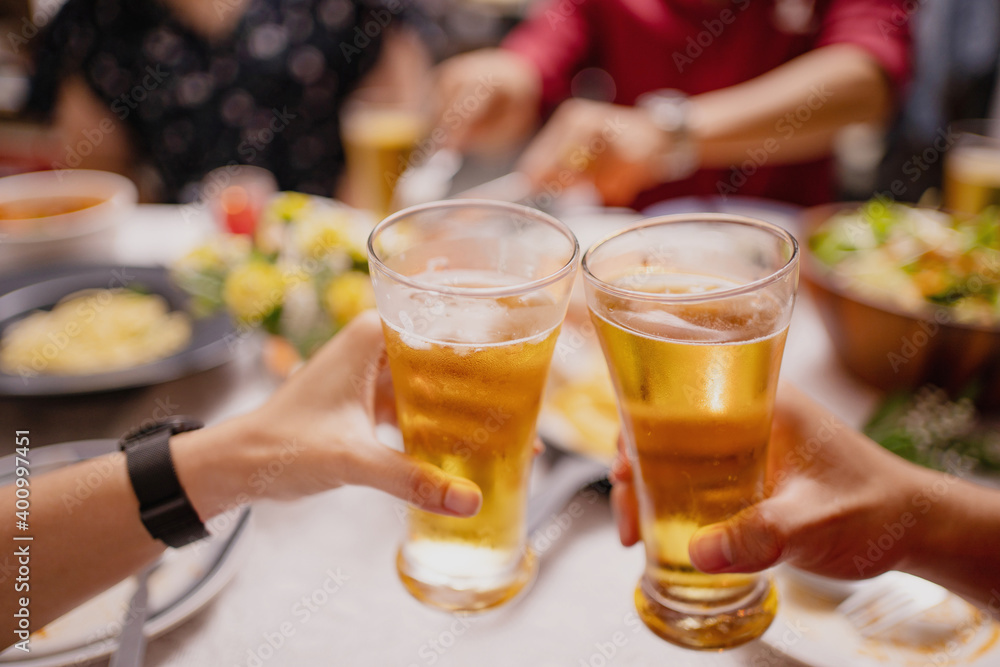 Close-up of people cheering of beer at a party. Group of Asian people having a New Year's party at home. Close-up of people cheering of beer at a party. Group of Asian people having a New Year's party at home.