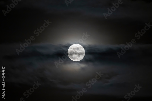 Full moon or Super moon phase with light shining in the blurred clouds for background