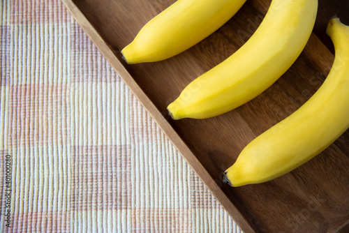 Fresh yellow bananas for healthy breakfast on wood plate