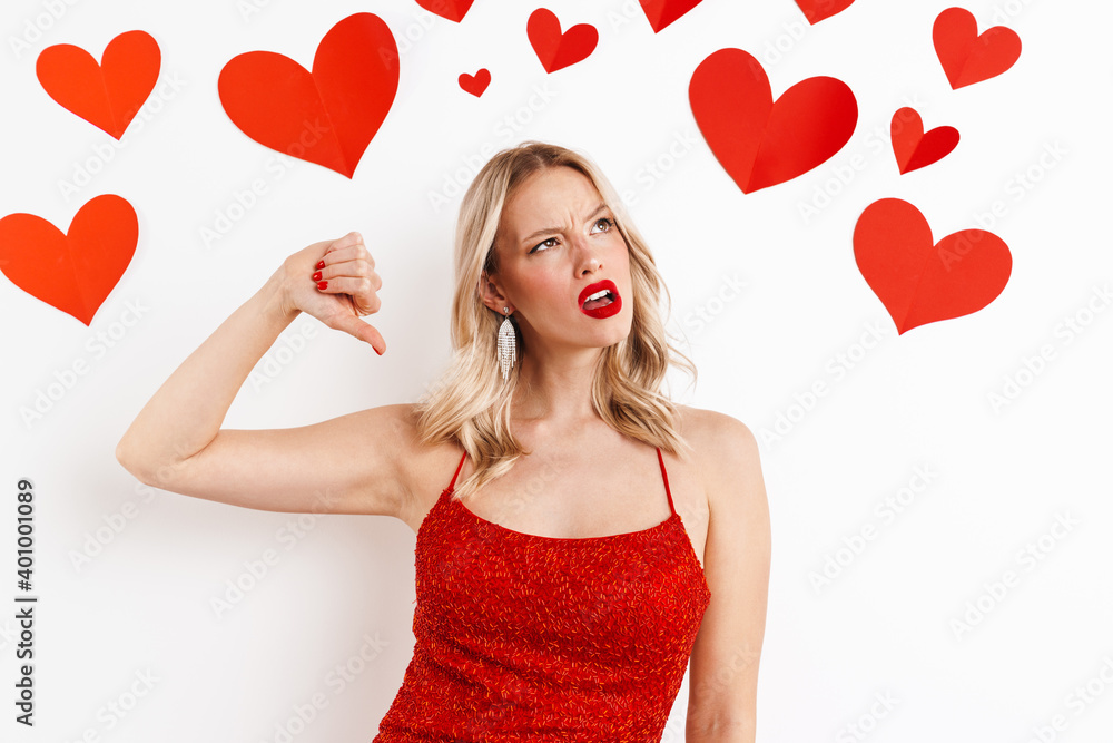 Upset blonde girl in red dress gesturing dislike sign with thumb down Upset blonde girl in red dress gesturing dislike sign with thumb down